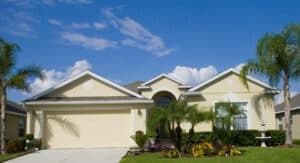 Pale yellow, single-story Florida home with matching garage door
