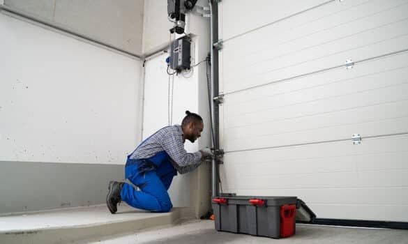Man repairing inside garage door track