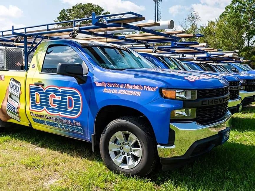 A row of trucks with DGD Garage Doors branding.