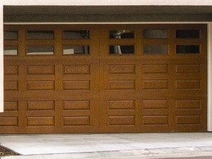 A wood garage door with glass accents on a Florida home.