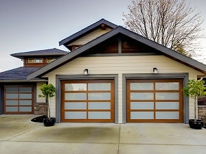 A home with beautiful wood and glass garage doors.