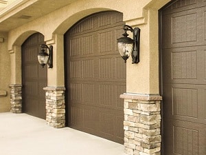 Three side-by-side garage doors with archways on a single-family home.