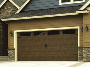 Brown and blue suburban home with a faux wood garage door